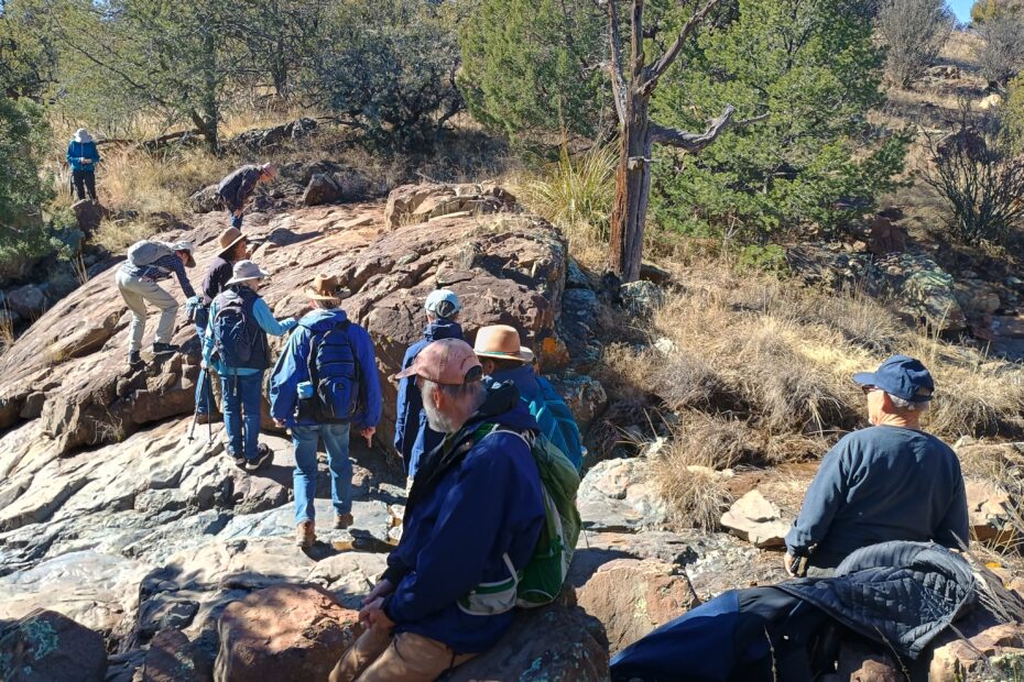 A group of people walking on boulders in a wooded area