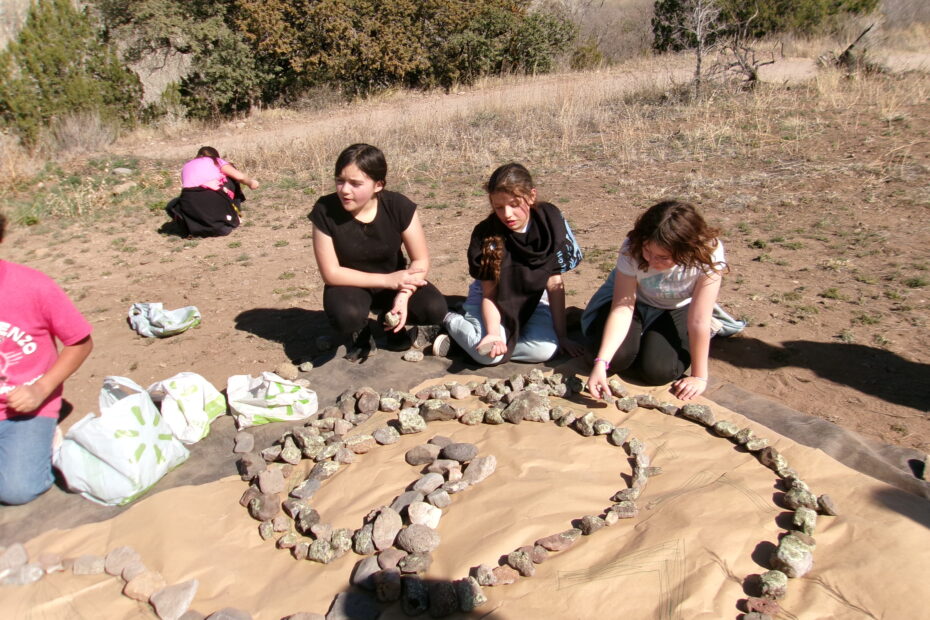 schoolchildren working together setting stones for a garden feature